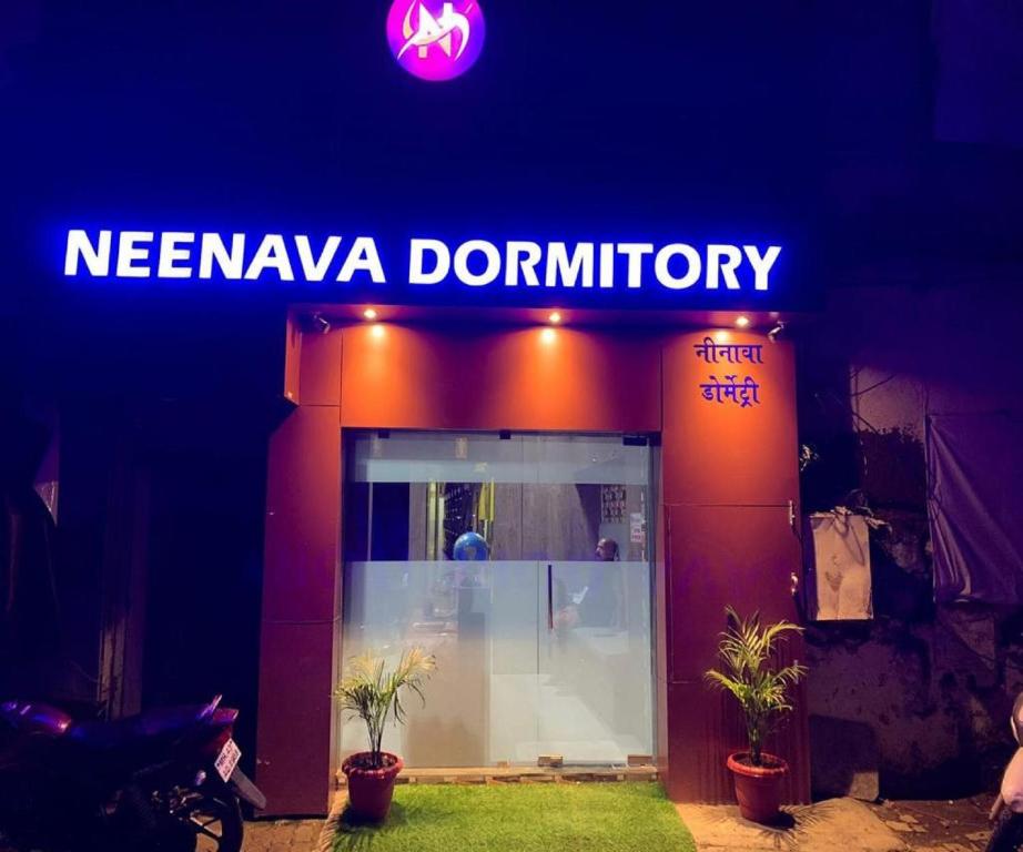 una señal para una tienda de donuts nevanova por la noche en Neenava Dormitory Asalpha en Bombay