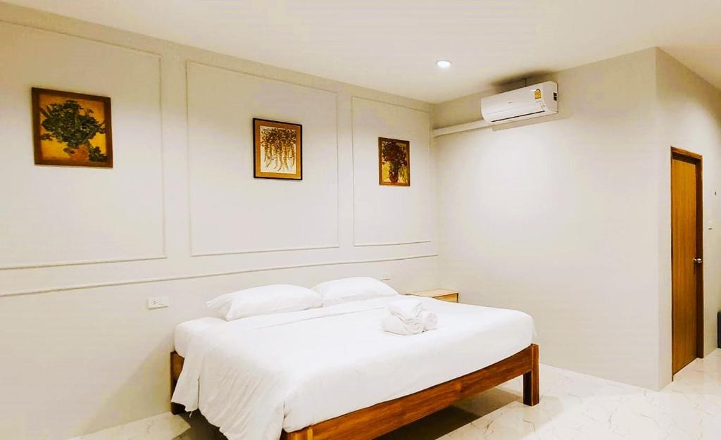 een witte kamer met een bed met witte lakens bij Chiang Khan Dwelling in Chiang Khan