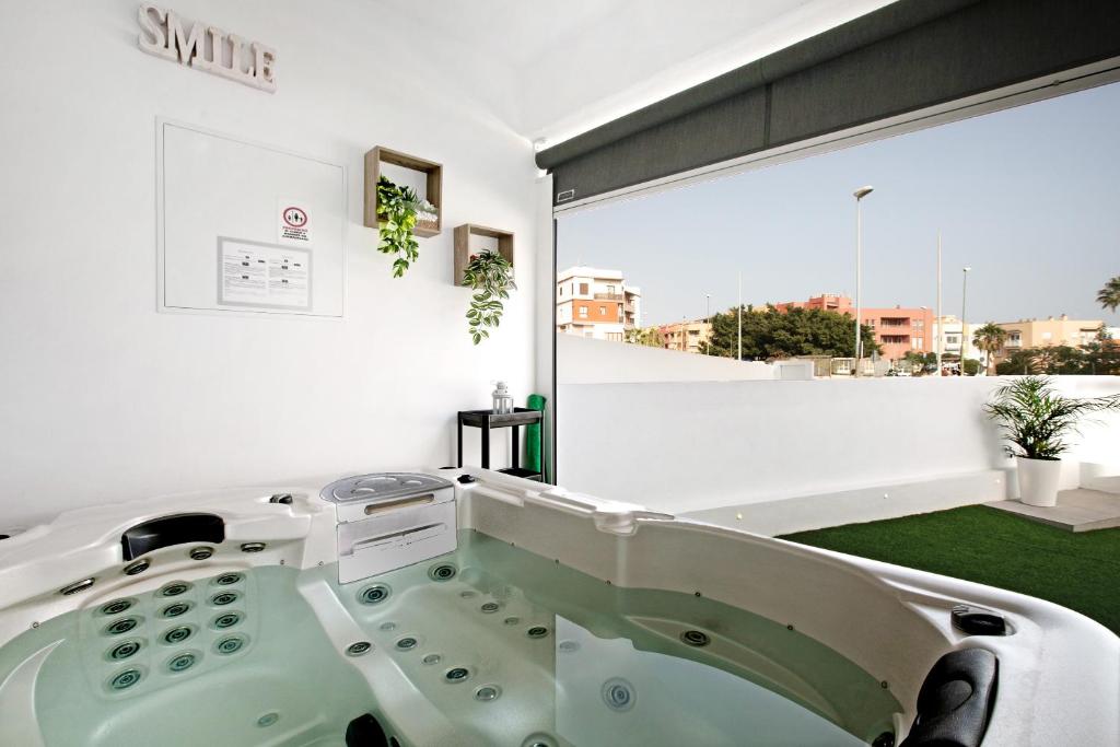 een badkamer met een groot raam en een bad bij El Ramonal Vacacional in Candelaria