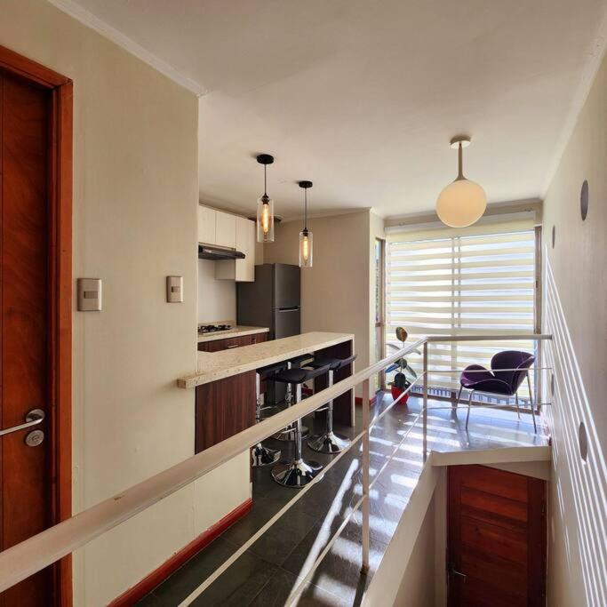 una cocina con una escalera que conduce a una sala de estar. en Departamento para 4 personas en 2° piso., en Talca