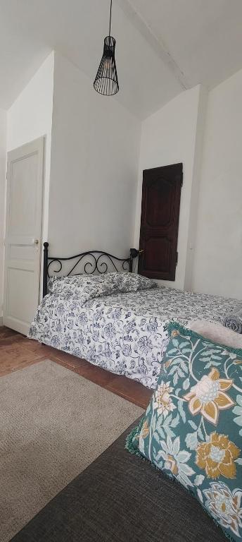 une chambre avec un lit avec un couvre-lit fleuri dans l'établissement Studio avec jardin à 10 mn à pied du centre ville, à Toulouse