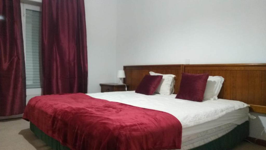 1 dormitorio con 1 cama grande con manta roja en Quinta do Lago Verde en Coruche