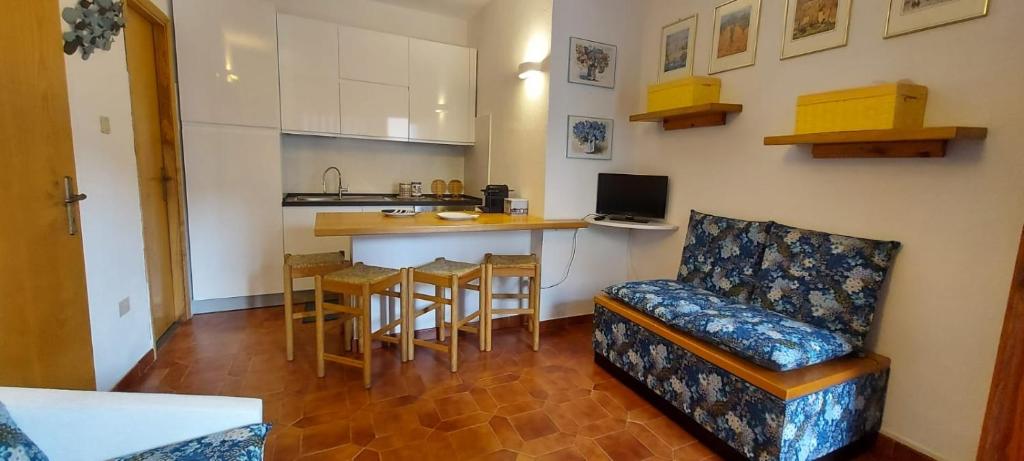 Il comprend un salon avec un canapé et une cuisine avec une table. dans l'établissement CASA PER VACANZE ANGELO, à Castelsardo
