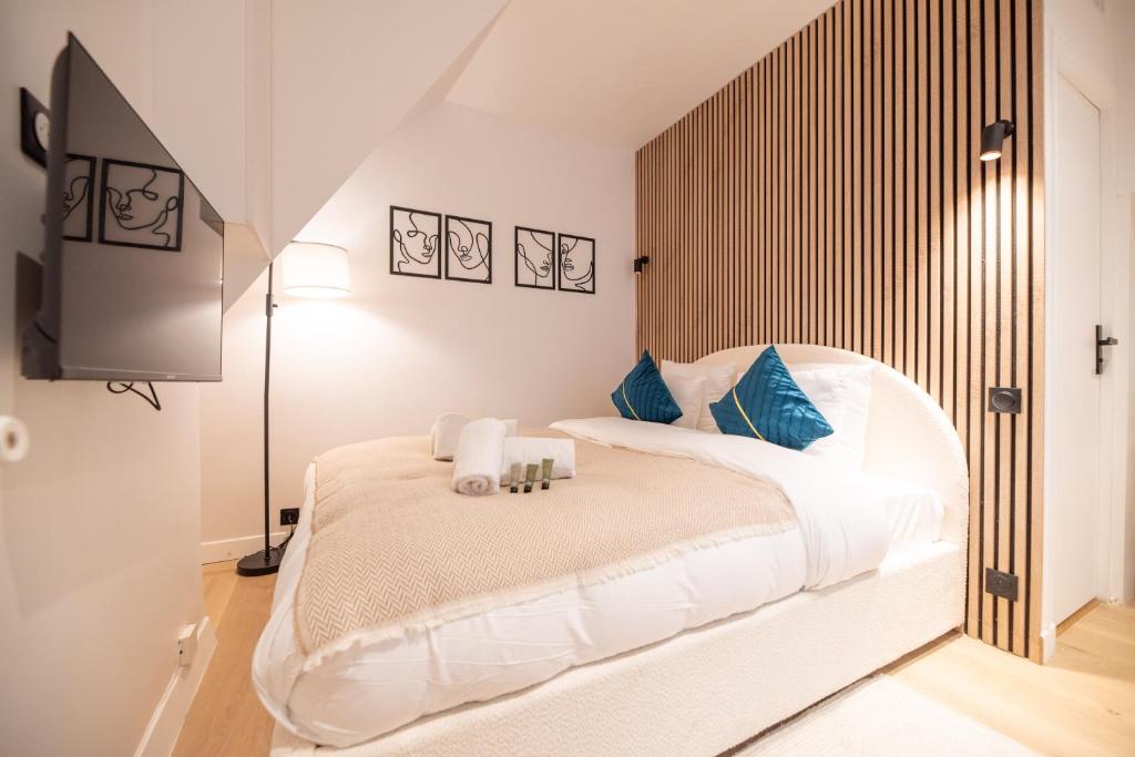 une chambre avec un grand lit blanc avec des oreillers bleus dans l'établissement Cosy flat / Tour Eiffel Area, à Paris