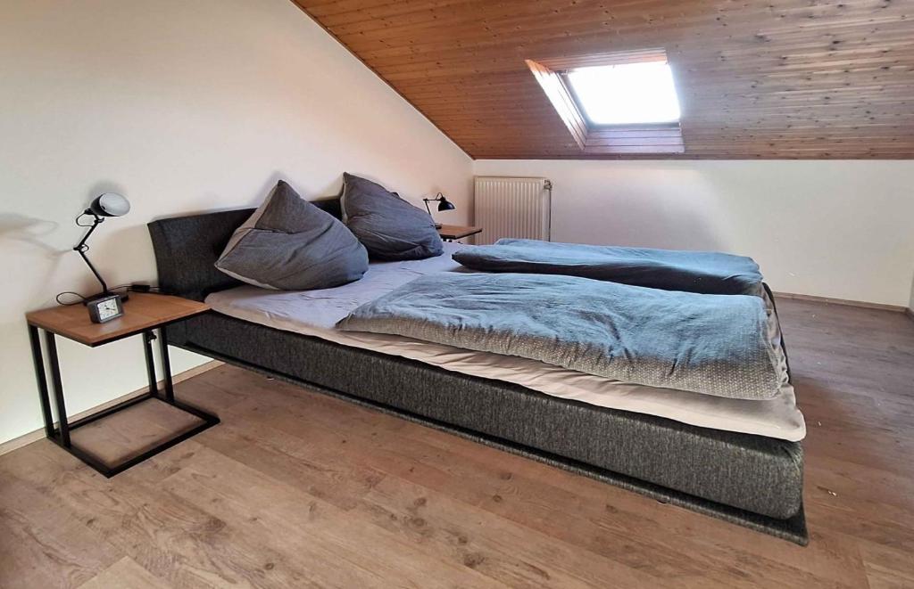 a bedroom with a large bed with blue sheets and a table at Plapperer`s Fewo in Schernfeld