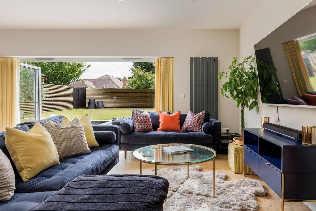 uma sala de estar com sofás e uma mesa de vidro em Luxury, eco-friendly 3 bed haven with plunge pool - Riverway Retreat Lux em Christchurch