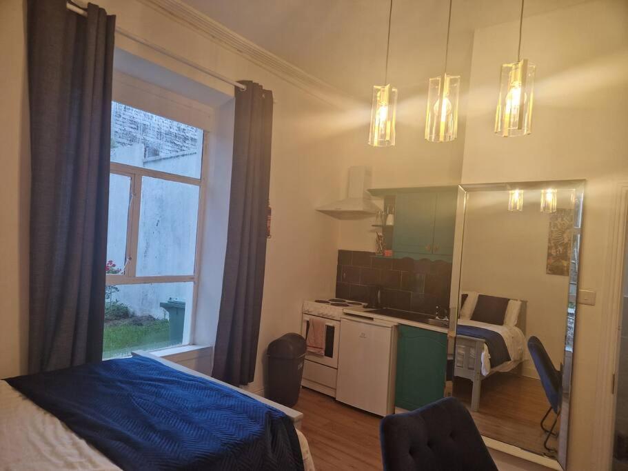 Habitación con cama y cocina con ventana en Lovely Studio - perfect weekend stay in Cork, en Cork