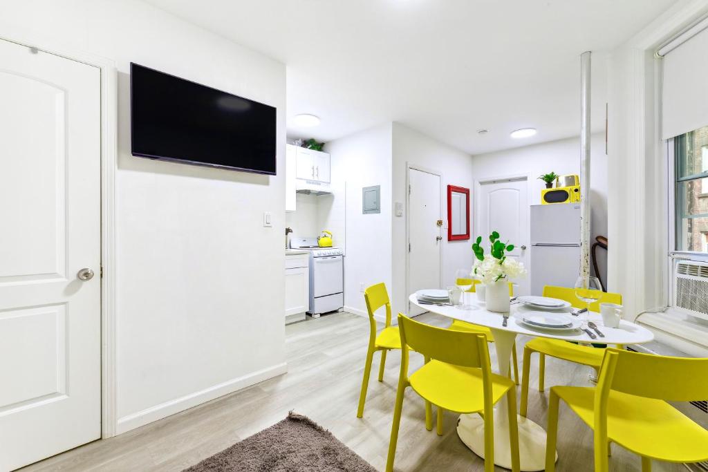 a kitchen and dining room with a table and yellow chairs at Peaceful Apartment in Lower Manhattan New York in New York