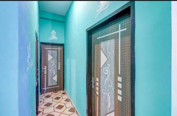 um quarto com duas portas e um piso de azulejo em Shri Radhe Krishna Bhawan em Lucknow