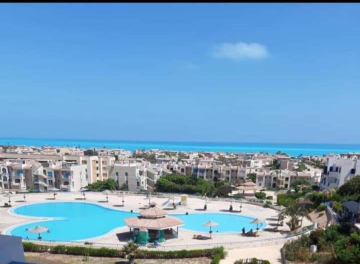 uma vista aérea de um resort com duas piscinas em شالية قرية اللوتس em El Alamein