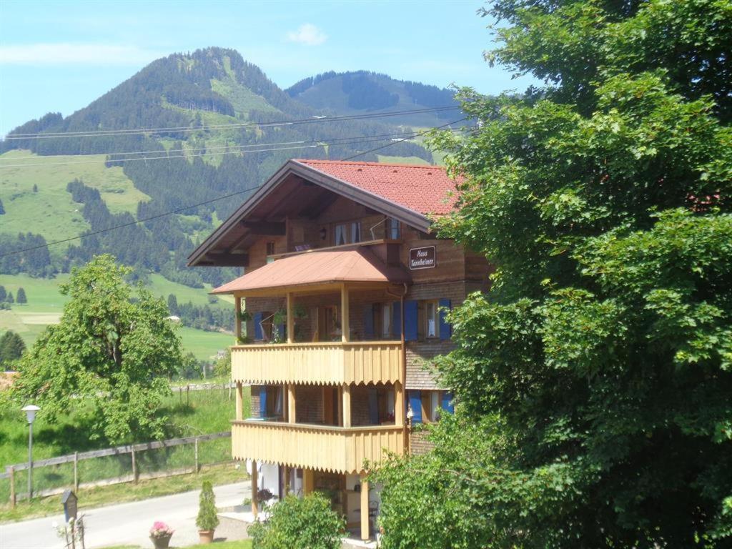 a large wooden house with a view of a mountain at Edelweiß Hörnerbahnen von Mai bis Oktober frei in Obermaiselstein
