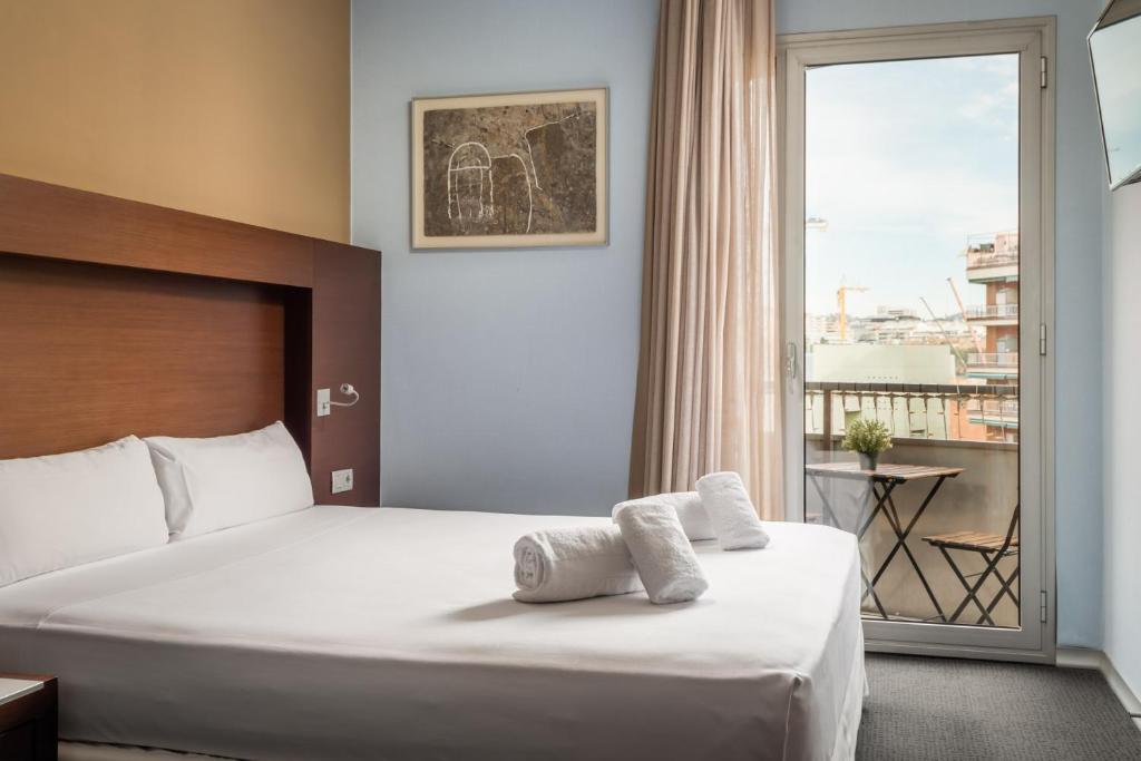 a hotel room with a bed and a large window at Hotel Madanis in Hospitalet de Llobregat