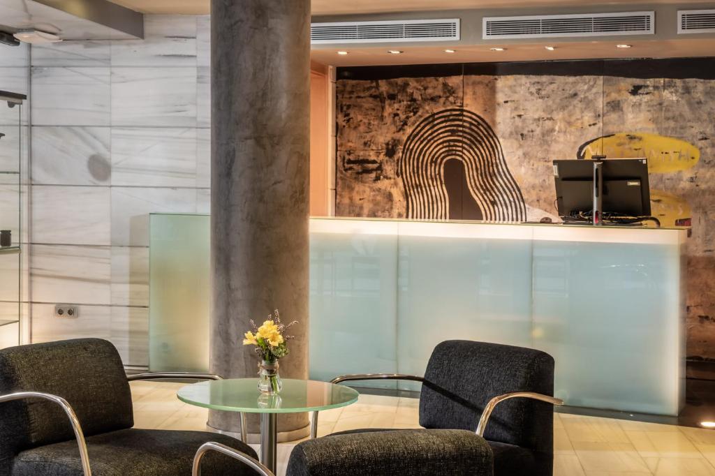 a lobby with two chairs and a glass table at Hotel Madanis in Barcelona