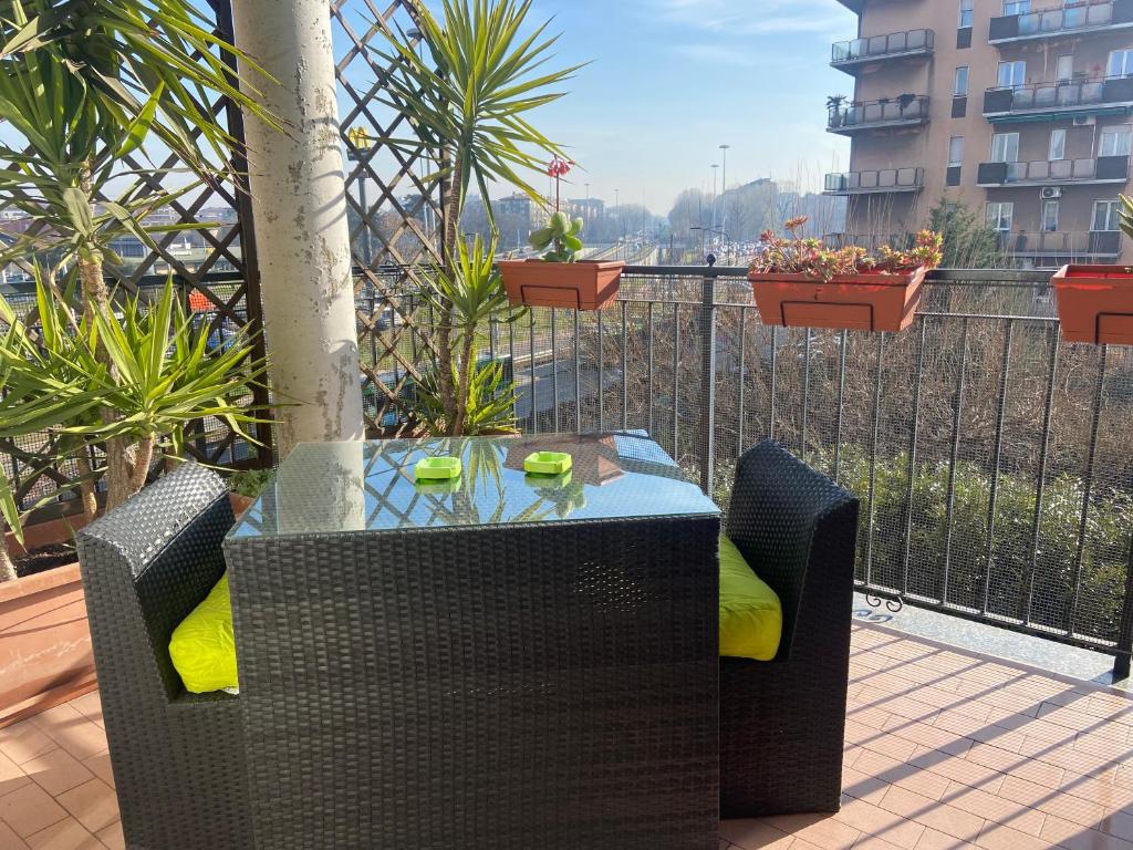 un tavolo e sedie su un balcone con piante di Appartamento linea diretta Duomo a Milano