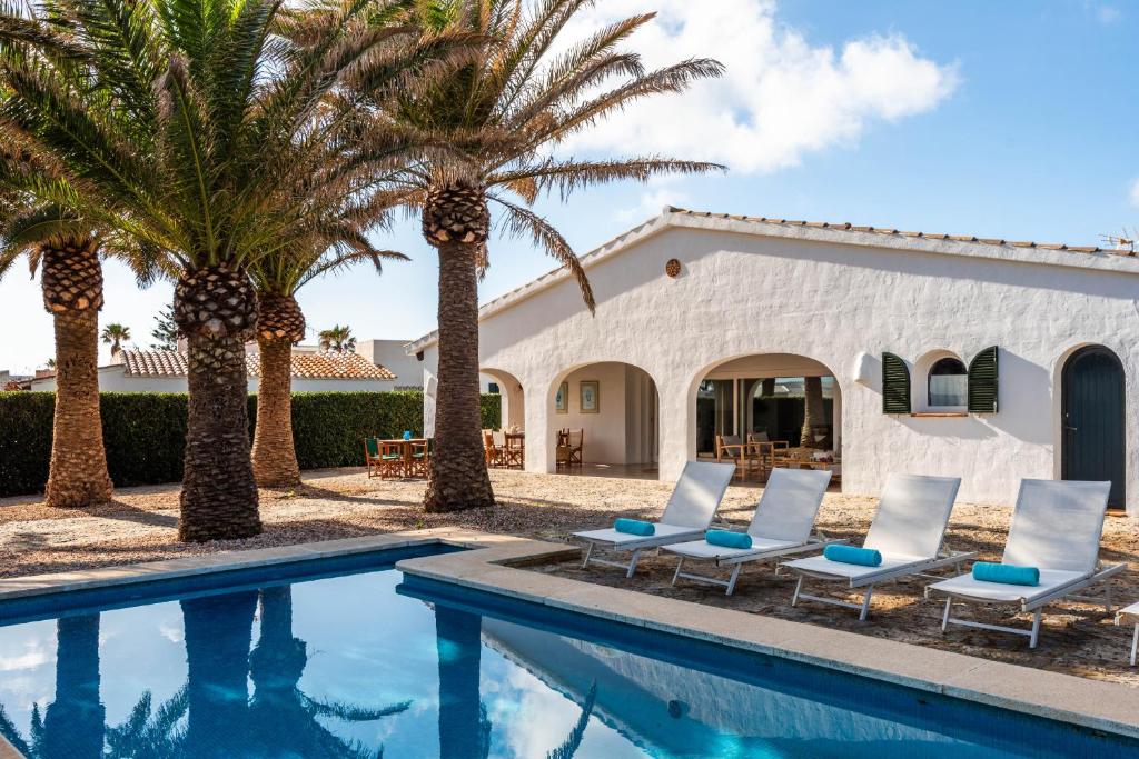 una villa con piscina e palme di Villa Bini Yaya - Cap den Font a Sant Lluís