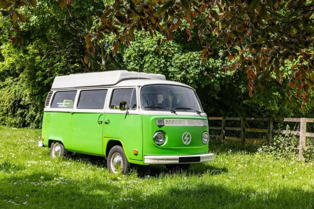 a green and white van parked in the grass at eDub Indie - The 100% Electric Classic Camper in Great Ouseburn