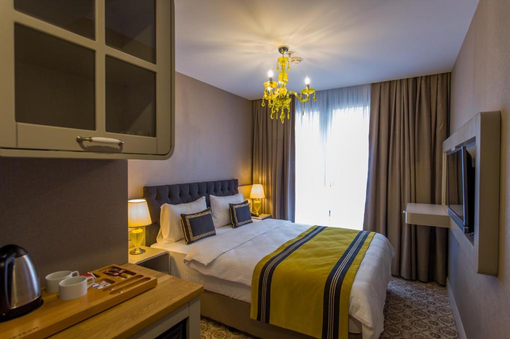 イスタンブールにあるHomelike Hotelのベッドとテレビが備わるホテルルームです。