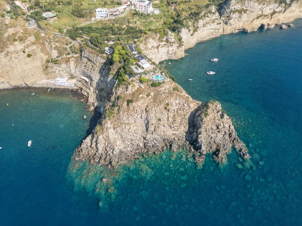 an aerial view of a rocky island in the ocean at Punta Chiarito Resort in Ischia