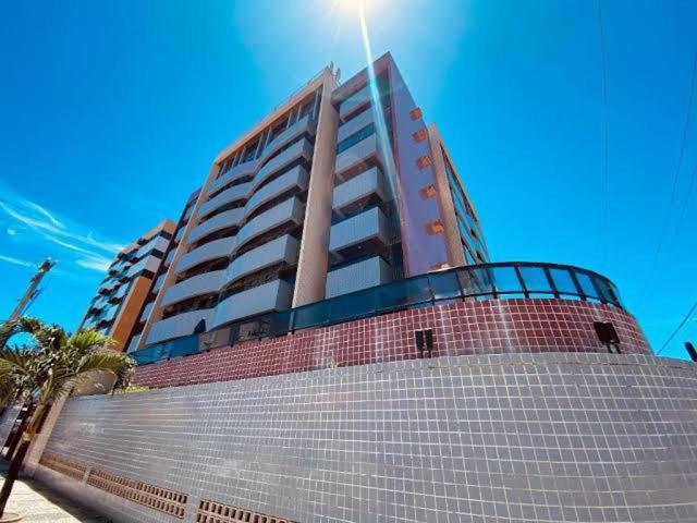 a tall building in front of a building at Ap studio a 50m da praia in Maceió