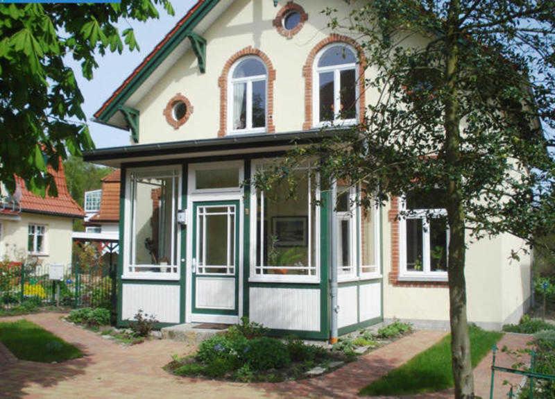 una casa con un verde y blanco en Haus Paula - Am Rhododendronpark, en Graal
