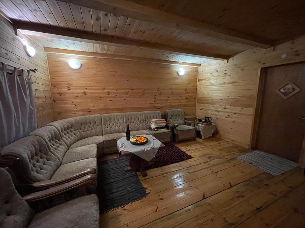 uma sala de estar com um sofá e uma mesa em Classic Latvian Sauna and Hot Tub in a quiet place em Mālpils