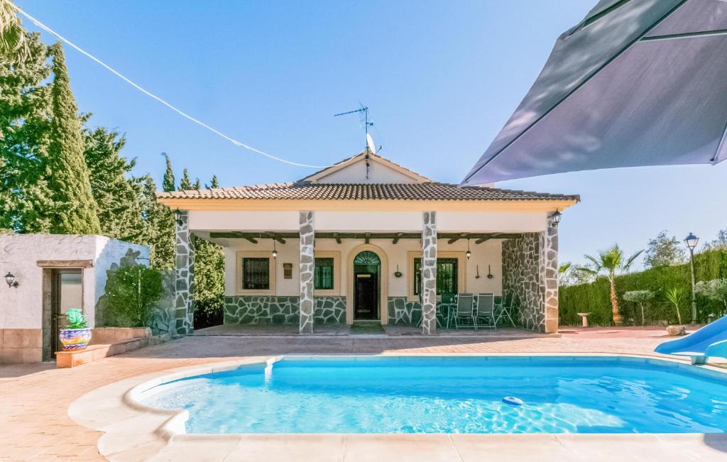 a villa with a swimming pool in front of a house at 3 Bedroom Awesome Home In Casariche in Casariche
