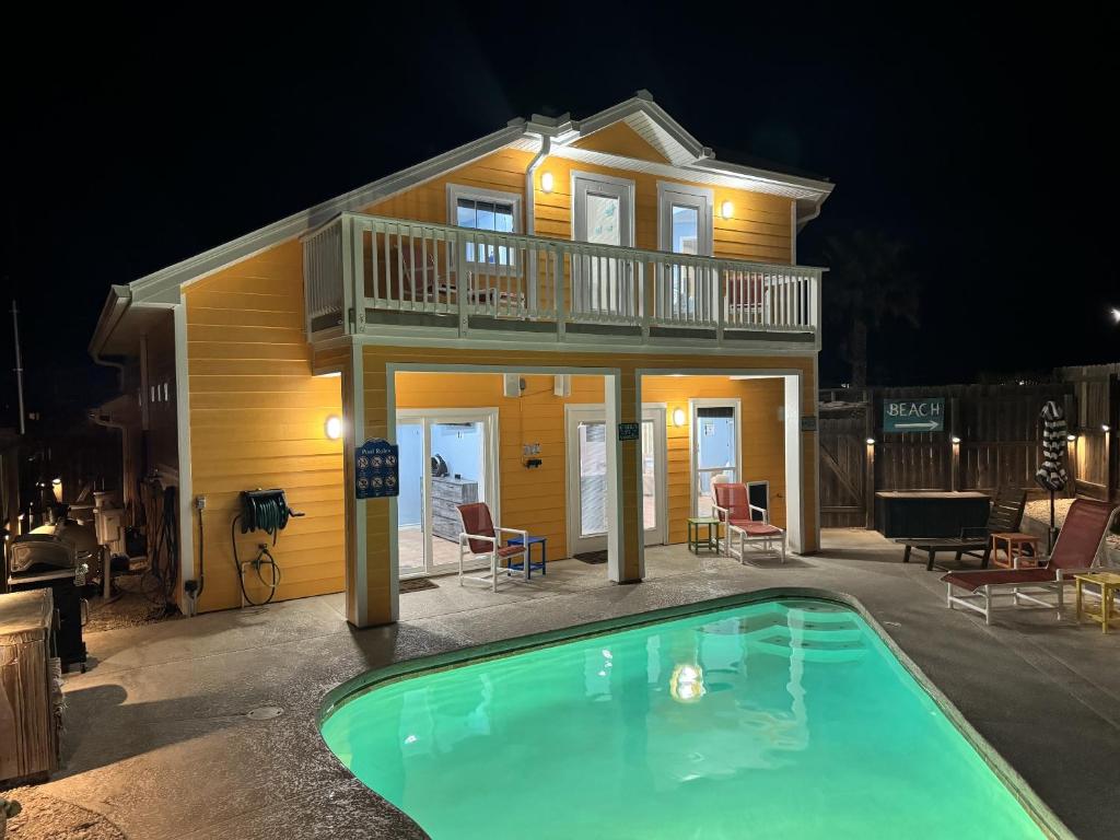 a house with a swimming pool in front of a house at LaJuana Iguana - House in Port Aransas