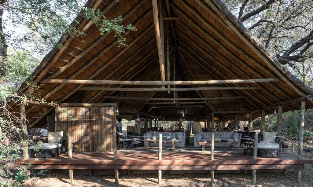 einem großen Holzpavillon mit Stühlen und Tischen in der Unterkunft Mashatu Tent Camp in Lentswelemoriti