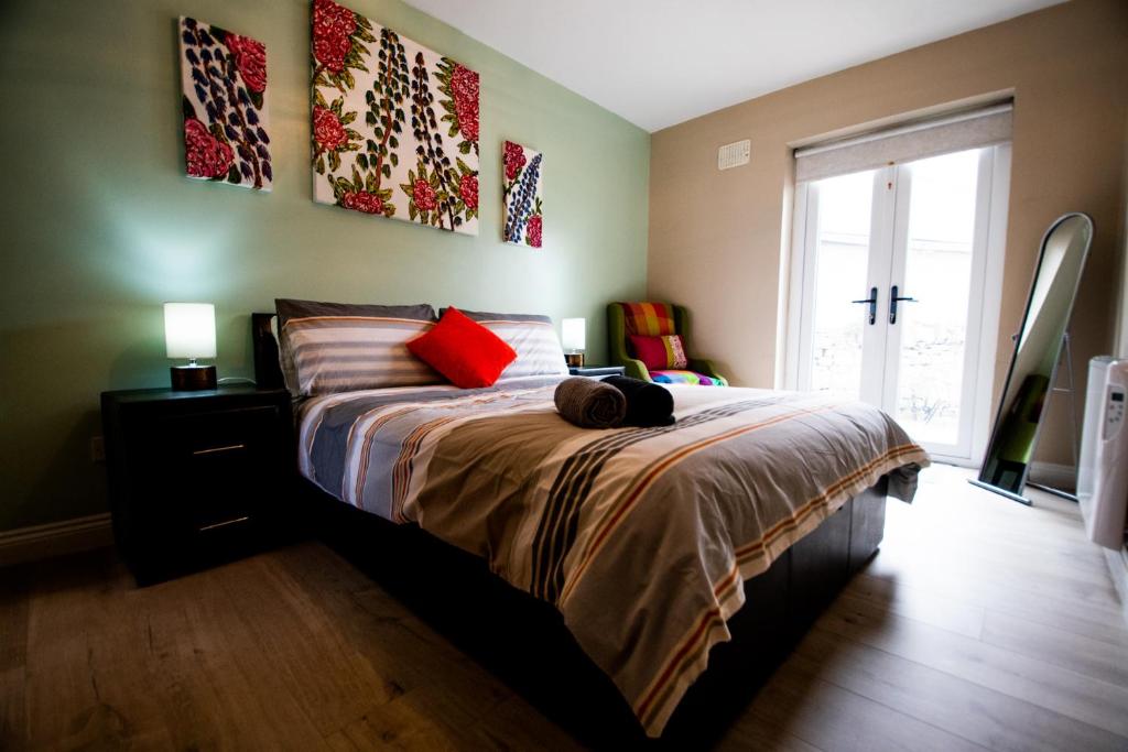 um quarto com uma cama com almofadas vermelhas e uma janela em Peak View Apartment Main Beach em Bundoran