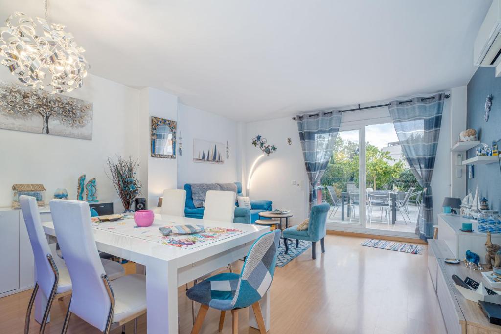 a dining room and living room with a white table and chairs at Apartamento ROYAL MARINE in Empuriabrava