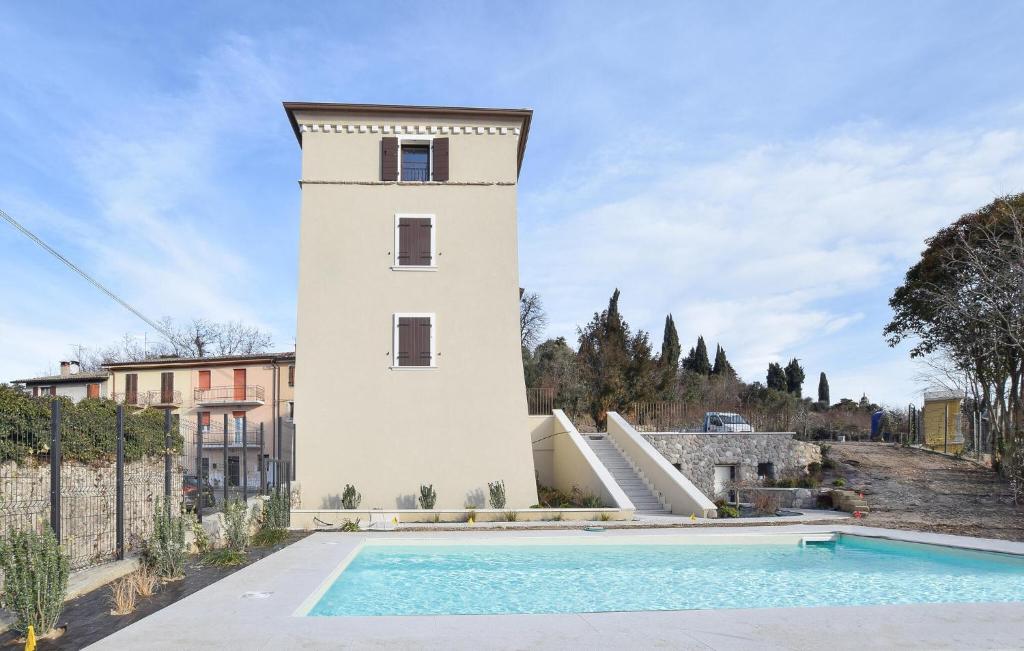 um edifício com uma piscina ao lado de uma torre em Nice Home In Costermano Sul Garda With Wi-fi em Costermano sul garda