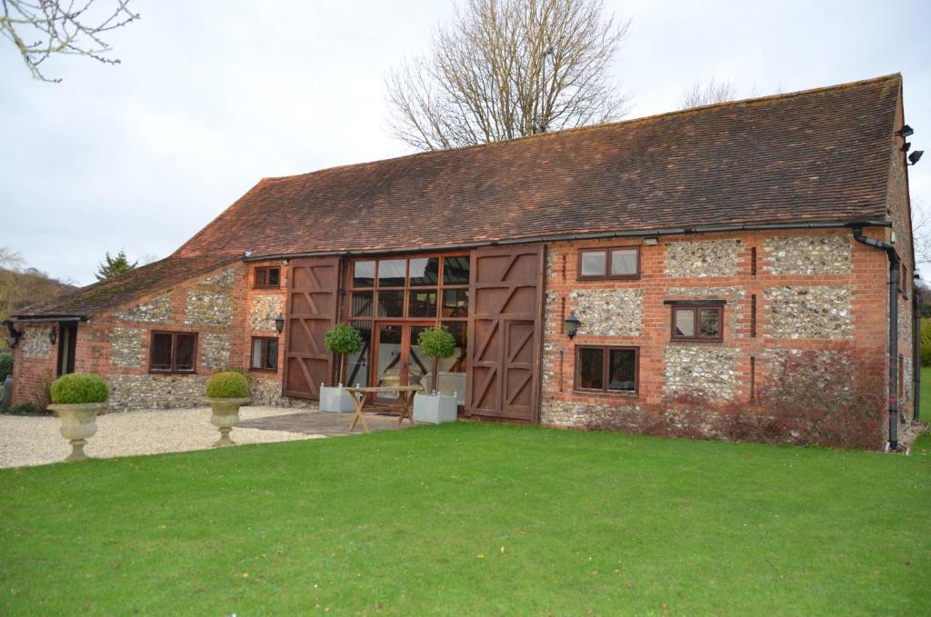 a large brick building with a green lawn in front of it at Barn conversion, Henley-on-Thames in Henley on Thames