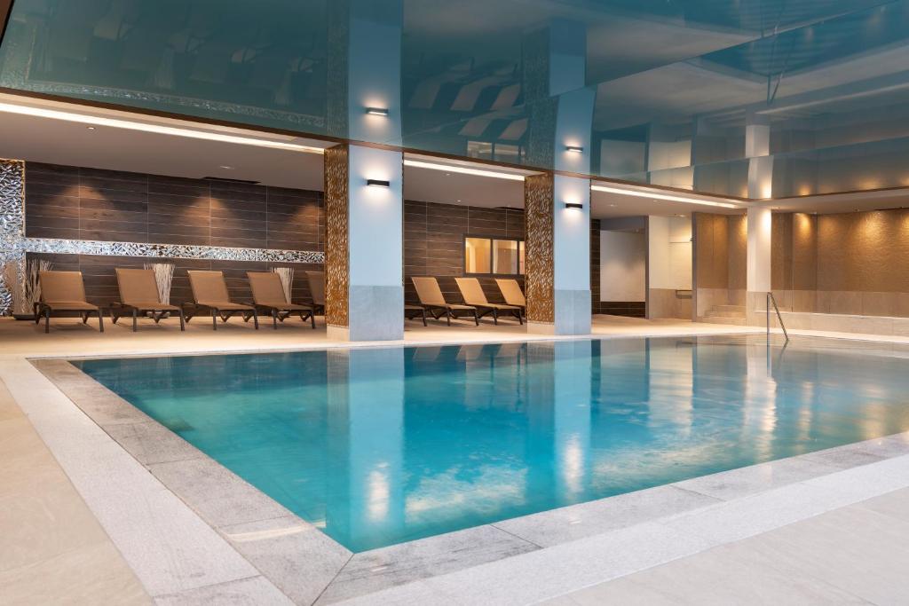 a large swimming pool in a building with chairs at Les Chalets Laska in Les Contamines-Montjoie