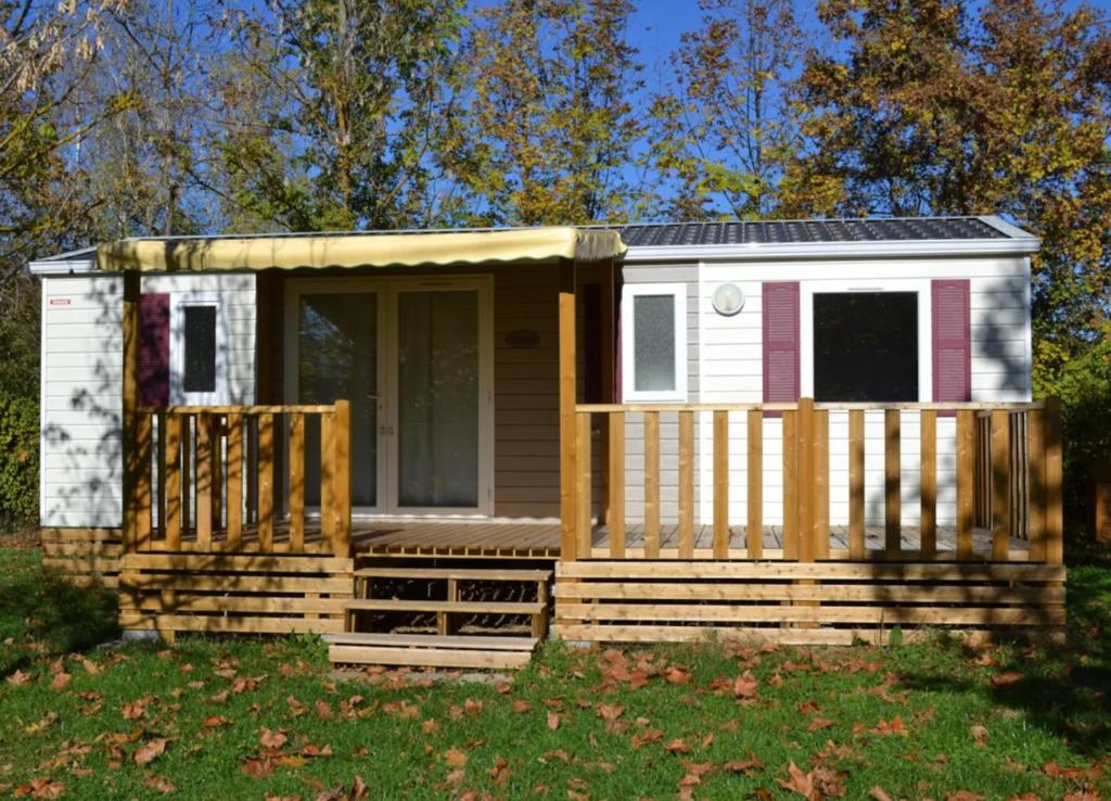 a tiny house with a porch and a deck at Mobil Home 6 personnes 206 in Mens