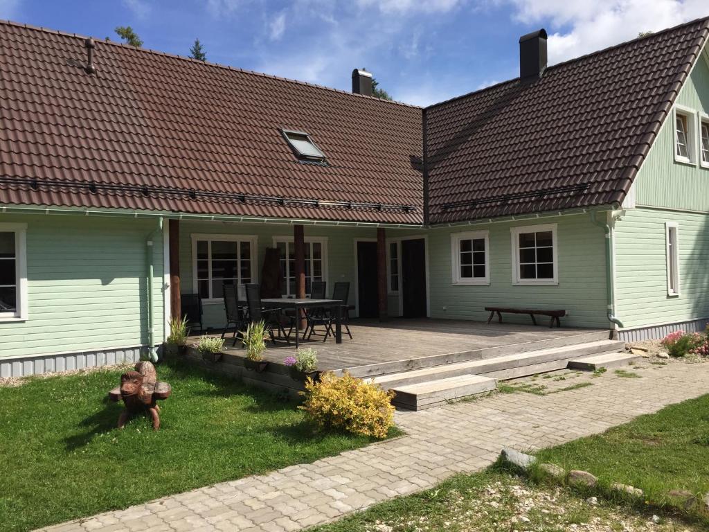 a green house with a patio in front of it at Pauka Holiday House in Palli