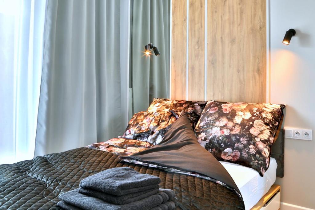 a bed with pillows on it in a bedroom at Komfortowy Apartament w Warszawie, Bemowo, Lazurowa, blisko Metra in Warsaw