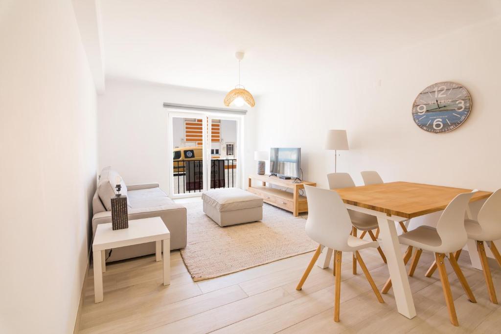 Una sala de estar blanca con una mesa y sillas. en Moon Beach House, en Praia da Areia Branca