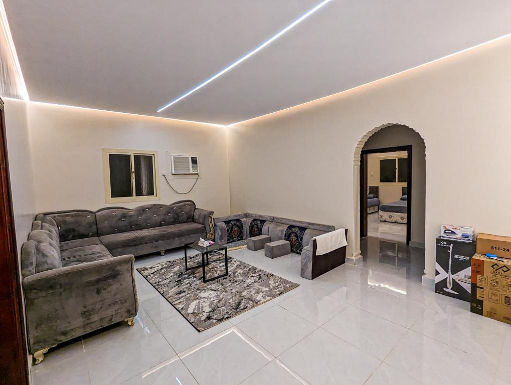 a living room with a couch and a table at Madina Luxe Apartments - 7 minutes to Haram by Car - Mount Uhud Views - Free Parking - Kitchen in Al Madinah