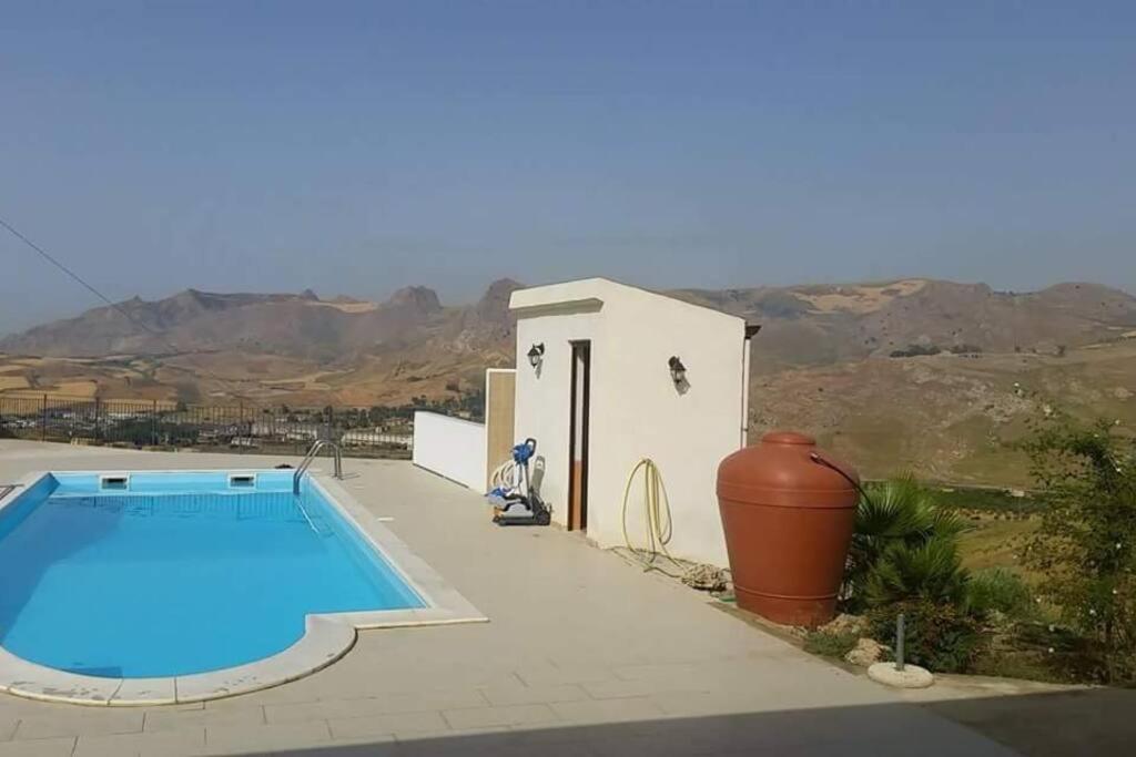 a swimming pool in front of a small building at Villa de vacance en Sicile 