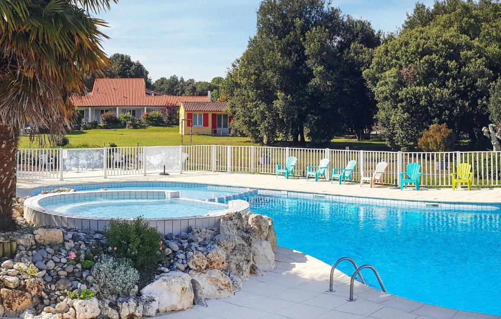 a swimming pool with chairs and a fence around it at Lovely Home In Saint-savinien With Outdoor Swimming Pool in Saint-Savinien