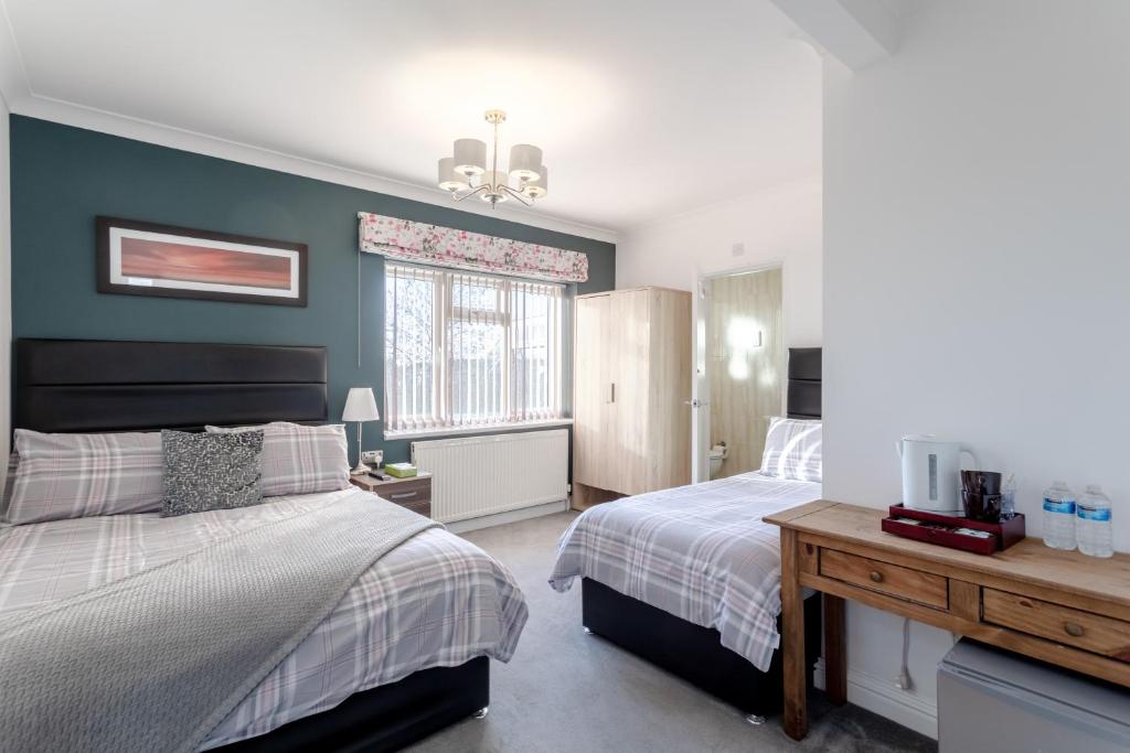 1 dormitorio con 2 camas y ventana en Apple House Wembley en Barnet