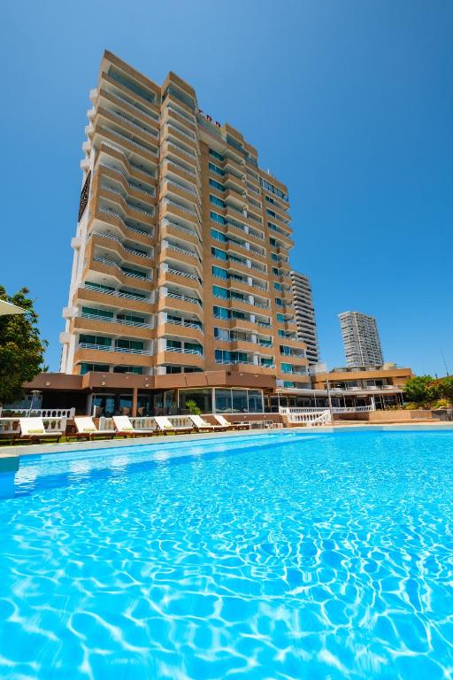 Un hotel con piscina frente al aominium. en Terrado Suites Iquique, en Iquique