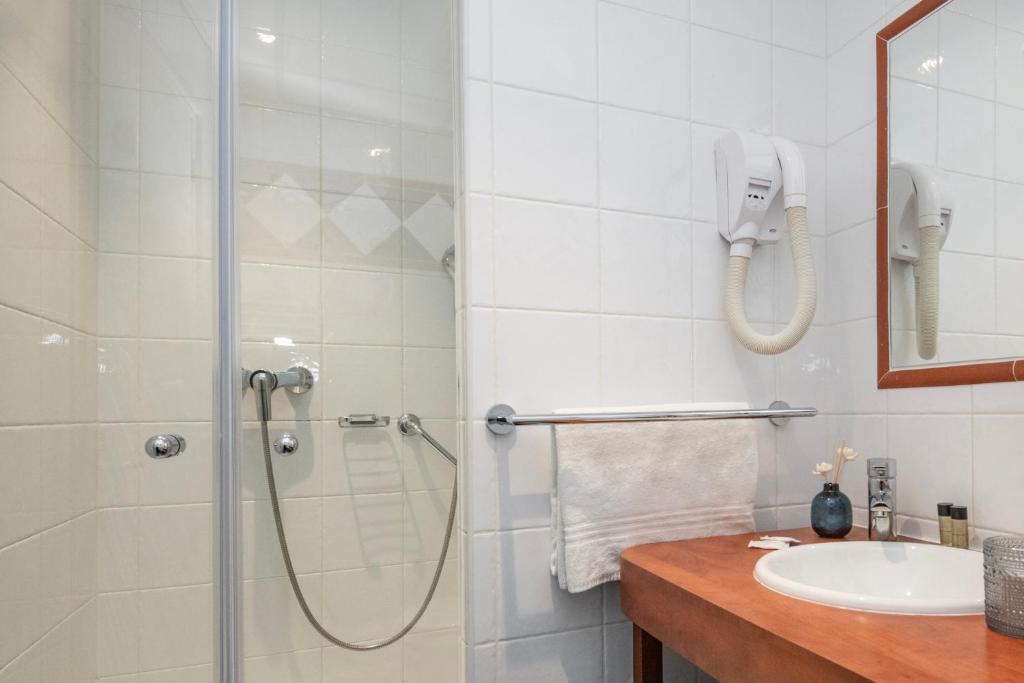 a bathroom with a shower and a sink at Hôtel Vendôme Menton in Menton