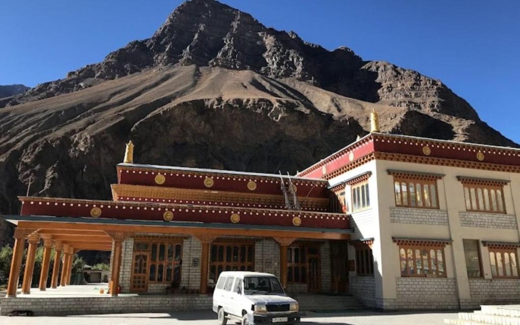 a white van parked in front of a building with a mountain at Namkha Homestay by StayApart in Tabo