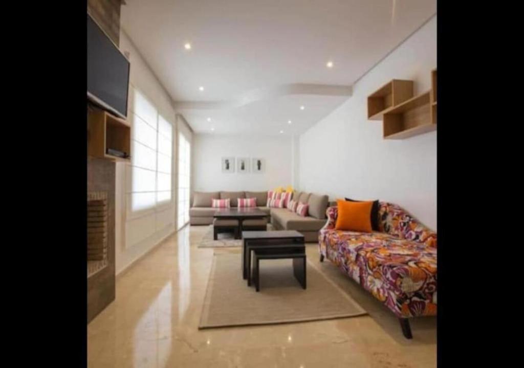 a living room with a couch and a table at Superbe appartement à la corniche de Casablanca in Casablanca