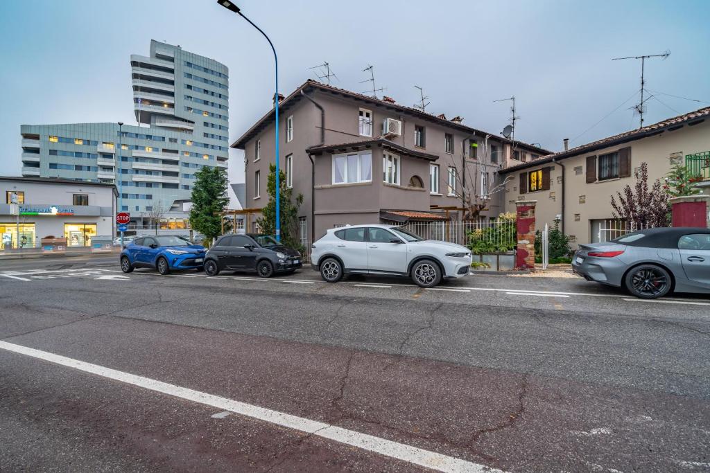 grupa samochodów zaparkowanych po stronie ulicy w obiekcie Cascina Conicchio - Metro Station - by Host4U w mieście Brescia