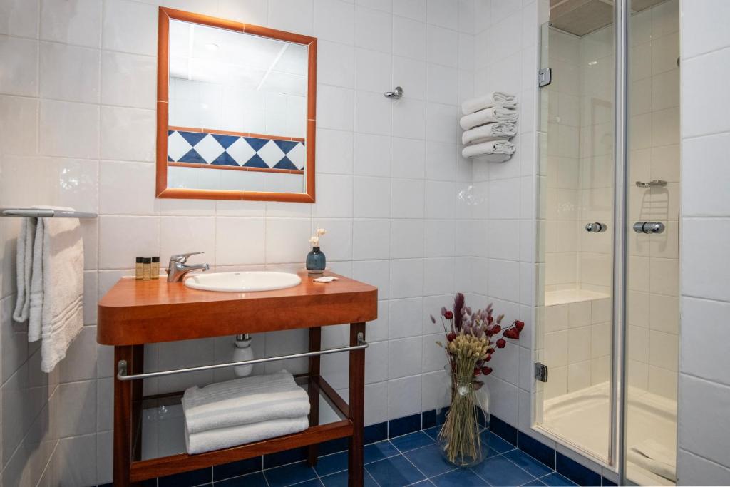 a bathroom with a sink and a shower at Hôtel Vendôme Menton in Menton