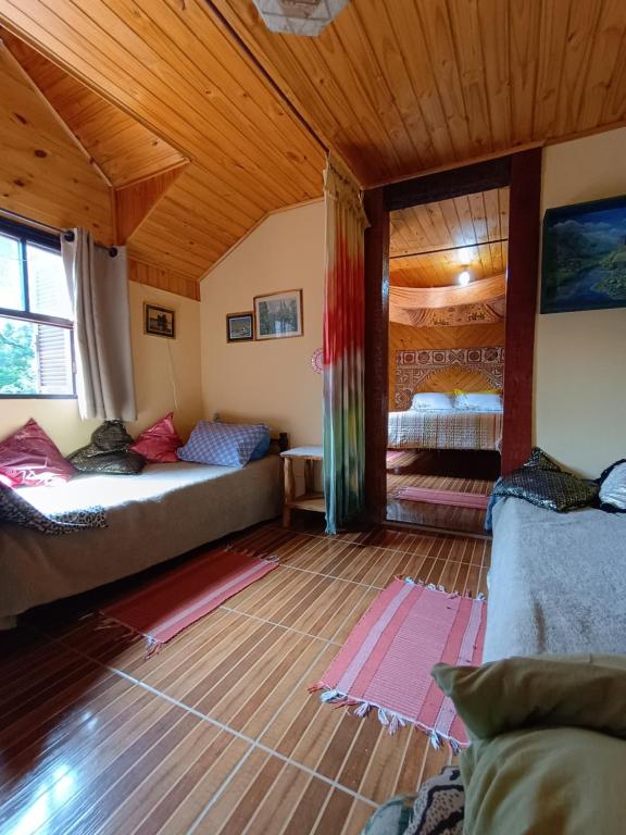 een kamer met 2 bedden en een houten plafond bij Casa Dell Angelo Apartamentos in Visconde De Maua