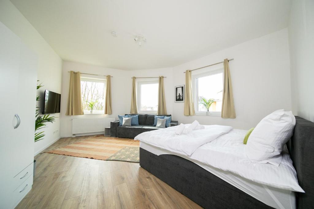 a bedroom with a large bed and a living room at Deluxe Apartments - 1 & 2 Bedroom - Zentral - 10 Min Messe in Düsseldorf