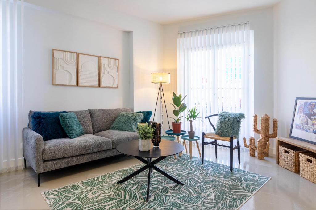 un soggiorno con divano e tavolo di Green Cocon - Belle maison pour 8 a Agen